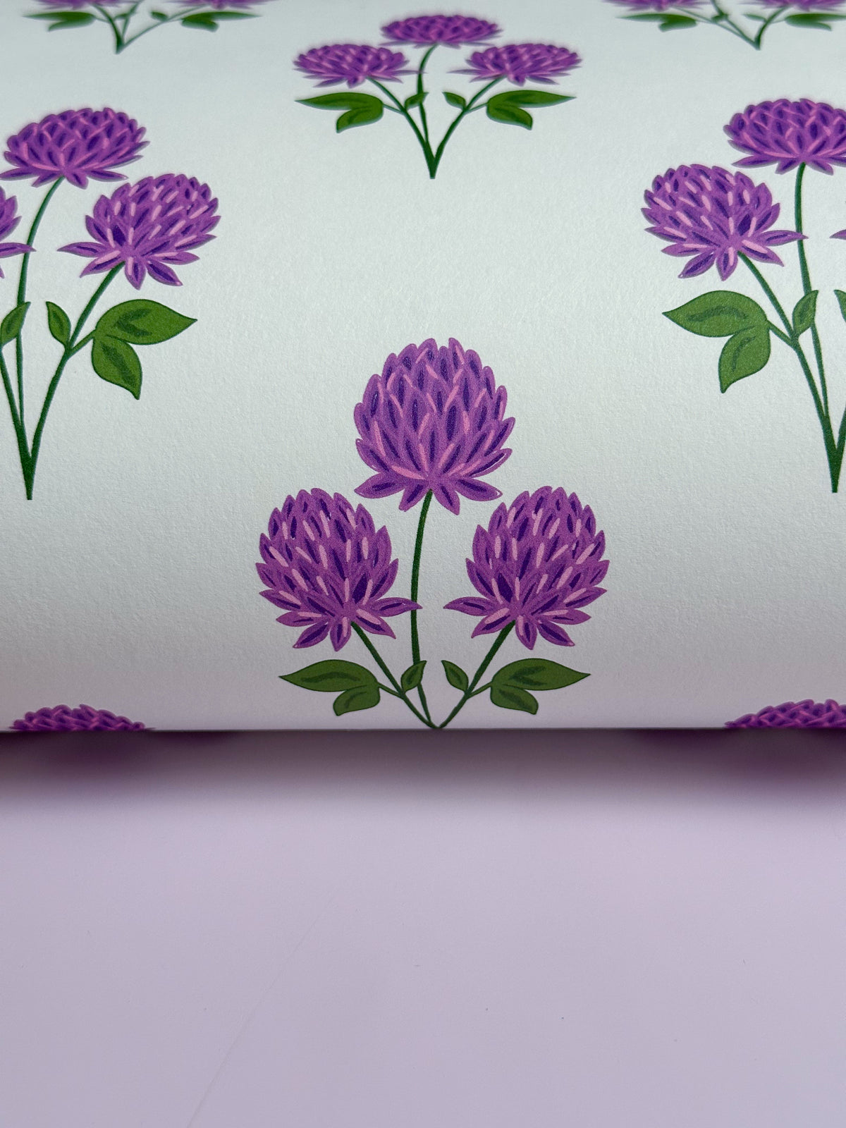 A close-up of Purple Clover floral wallpaper with Farrow and Ball Sugared Almond paint 
