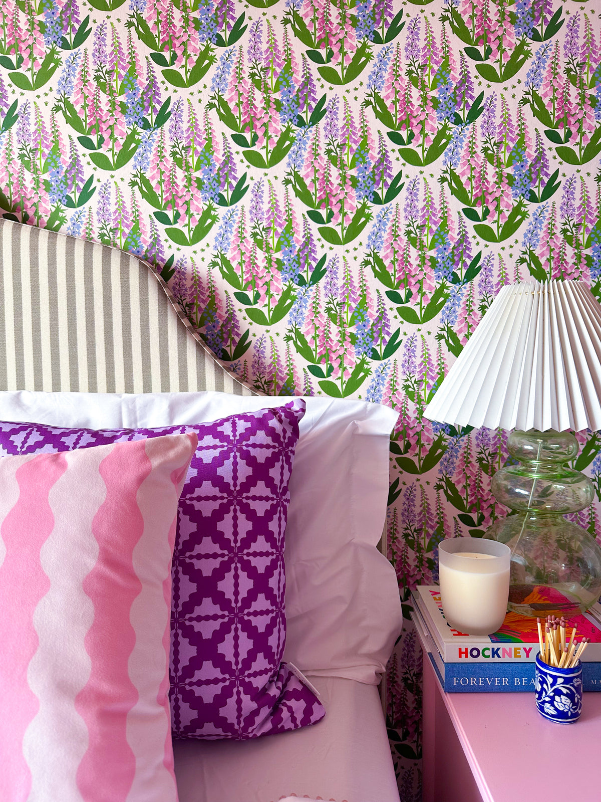 Summer Spires delphinium and foxglove wallpaper in pink, purple, green colours in an elegant modern English bedroom